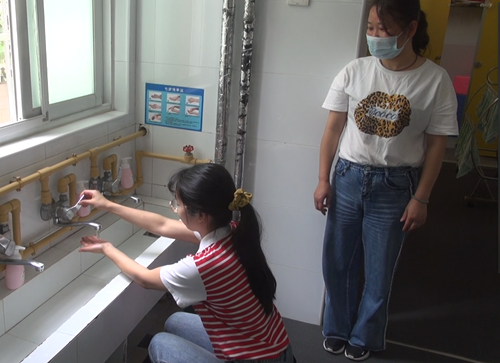 教师引导幼儿进入盥洗室洗手
